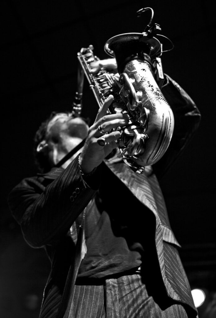 Saxofonista tocando el saxo en alto visto en contrapicado, fotografía en blanco y negro