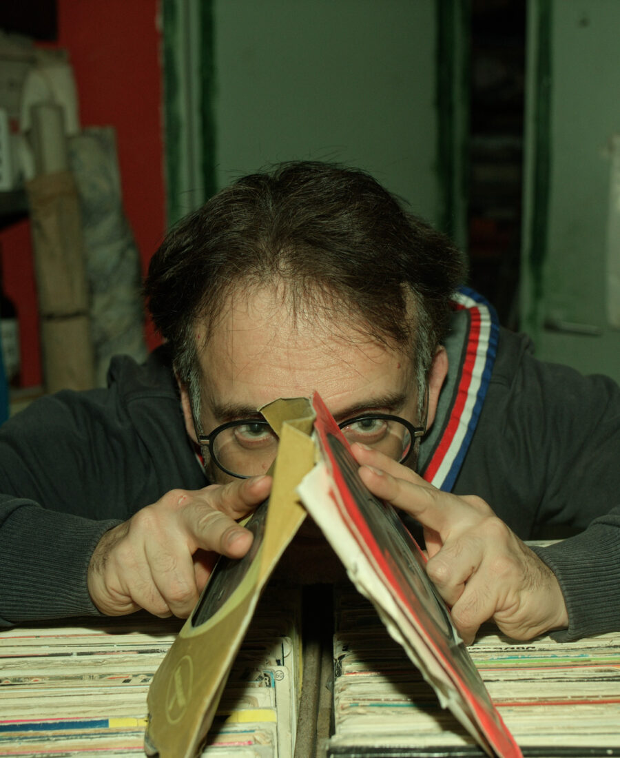 Autorretrato asomado entre discos de vinilo, con gafas y la mirada por encima de las fundas
