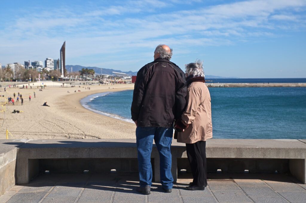 Pareja mayor de espaldas mirando la playa de la Barceloneta